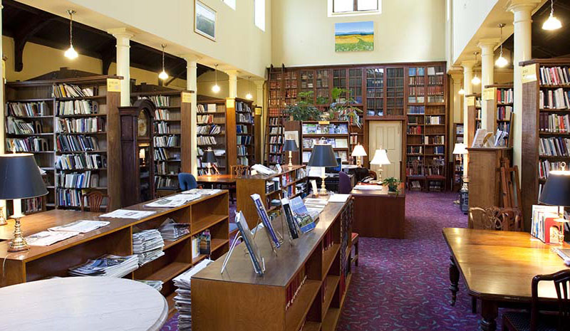A photo of the legislative library. There are several shelves of assorted books in view.